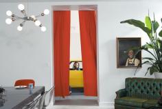 At the edge of the dining room, with its eclectic collection of fixtures and furnishings, orange velvet curtains playfully frame an opening to the skylight garage. It serves as a kind of sculpture gallery for motorcycles and cars, including one of Surratt's favorites, a yellow 1968 Camaro Rally Sport.