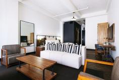 
                    
                        Refinery Hotel New York City // seating area with striped throw pillows.
                    
                