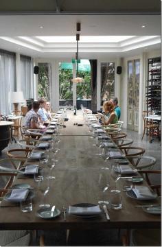
                    
                        The dining room is soaked with natural light and cane chairs lend a tropical feel that spills onto a private courtyard where guests mingle.  The elegant setting reminds me of Hotel Centennial yet the casual vibe of this room makes me feel as though I am in the comforts of my own home.  A wooden communal table sitting thirty is a permanent centrepiece and is hosting an entire group for lunch today.
                    
                
