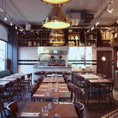 
                    
                        The bar, illuminated in red, sports a large painting of a fishmonger and butcher by Ninth Seal - adding a touch of contemporary in an otherwise traditional setting. Comfy banquettes circle the bar, metal drop-lights and hardwood tables are reminiscent of the West London boozer it once was...
                    
                