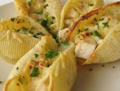 Great for an appetizer or a main dish. . Mini Chicken Alfredo Makes 12 servings of 24 shells 24 dry jumbo pasta shells, (about 6 oz.) 2 Tbsp. olive oil 1 lb. boneless, skinless, chicken breast halves, seasoned with salt and pepper Sauce: 1 1/2 c. heavy cream 2 cloves garlic, chopped 1 stick unsalted butter (8 Tbsp.) 1 1/2 c. grated Parmesan, divided 2 tsp. black pepper 4 Tbsp. chopped fresh parsley, divided Preheat broiler with rack 5 inches from element. Spray two 24-cup mini muffin tins with nonstick spray; set aside. Bring a large post of salted water to a boil. Cook shells in boiling water until al dente, 12-15 minutes; drain and rinse under cold water. Heat oil in a skillet over medium heat. Add chicken and saute until cooked through, 8-9 minutes per side; cool slightly, then chop into small pieces. Warm cream and garlic in a large saucepan over medium-low heat until steaming. Whisk in butter until melted. Add 1 c. Parmesan, 2 tsp. pepper, and 2 Tbsp. parsley. Increase heat to medium-high and simmer until reduced to 1 cup, about 10 minutes. Stir in chicken and remove from heat. Fill each shell with 1 heaping Tbsp. chicken mixture. Stagger filled shells, open ends up, in every other muffin tin well to prevent them from sticking to each other. Sprinkle shells with remaining 1/2 c. Parmesan. Broil shells until sauce bubbles and Parmesan melts and is golden, about 2 minutes. Garnish shells with remaining 2 Tbsp. parsley