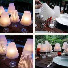 Made out of fragile parchment, each set contains 3 different shades with cute and whimsical designs that are printed in a faint white. All you need to do is take them out of the package roll them up, drop a candle into a wine glass and add the lampshade. That’s it. Instantly the white pattern is transformed to a darker shade (as if it were a shadow) and a wine glass is turned into a sweet miniature lamp.

Save-on-Crafts has a great instructions on how to make your very own Wine Glass Candle Lamp

Materials
8-1/2″ x 11″ (21.8cm x 28cm) sheets of vellum (one per lamp)
Scissors
Scissors with decorative blades
Decorative paper punch in desired shape
Glue pen
Wineglass
Votive candle or a LED Battery Operated Tea Light
Candle putty (floral clay)

1.Lampshade Pattern (PDF file click here)
To view this file, you will need Adobe Acrobat Reader

2. Trace the lampshade pattern onto the sheet of vellum. Cut the straight ends and the inner curve using plain scissors with decorative blades.

2. Punch designs about 1″ (2.5 cm) from the lower edge, spacing the designs evenly.

3. Apply a thin line of glue (a glue pen works well for this) to one straight end. Lap the other end over the glued end, forming the shade.

4. Secure the votive candle and set the lampshade atop a wine glass

