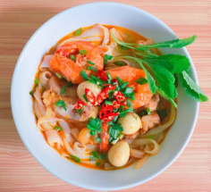 Free A vibrant bowl of Vietnamese noodle soup with shrimp, herbs, and quail eggs. Stock Photo